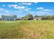 Beautiful yard with lush green grass, scattered trees and two buildings on a sunny day with scattered clouds at 6679 Cr 613, Bushnell, FL 33513