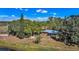 Aerial view of a single-story brick home surrounded by mature trees and green grass at 6988 Blue Cedar Rd, Leesburg, FL 34748