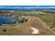 Expansive aerial view of rural property featuring a pond, fields, and a scattering of trees at 6988 Blue Cedar Rd, Leesburg, FL 34748