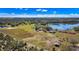 Wide aerial shot displaying a property with home, pond, groves, and open fields at 6988 Blue Cedar Rd, Leesburg, FL 34748