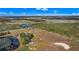 Expansive aerial view of rural property featuring a pond, fields, and a scattering of trees at 6988 Blue Cedar Rd, Leesburg, FL 34748