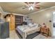 Comfortable bedroom with tile flooring, closet, a bed with a unique quilt, and an armoire at 6988 Blue Cedar Rd, Leesburg, FL 34748