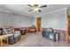 Spacious living area with a ceiling fan, tile floors, wood paneling, and a comfortable recliner at 6988 Blue Cedar Rd, Leesburg, FL 34748