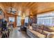 Cozy living room features wood paneled walls, fireplace, and plush seating at 6988 Blue Cedar Rd, Leesburg, FL 34748