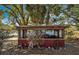 Outdoor patio with wooden frame, corrugated metal walls, and beautiful lake view at 6988 Blue Cedar Rd, Leesburg, FL 34748