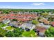 Shows an aerial view of a neighborhood with houses with well-maintained lawns and mature trees at 733 Palma Dr, The Villages, FL 32159