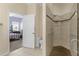 Tiled walk-in shower features grab bars and an entrance to a bedroom with a wrought iron bed at 733 Palma Dr, The Villages, FL 32159