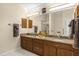 Bathroom with double sink vanities and a decorative mirror above, accented with bronze hardware and fixtures at 733 Palma Dr, The Villages, FL 32159