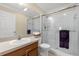 Bathroom with a shower stall and clear glass doors, accompanied by a white sink and commode at 733 Palma Dr, The Villages, FL 32159