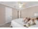 Bedroom with neutral walls has a white bed, fan, and side table lamp, offering a serene and inviting atmosphere at 733 Palma Dr, The Villages, FL 32159