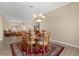 Cozy dining room area with a wooden table, chandelier, and a view of the living room at 733 Palma Dr, The Villages, FL 32159