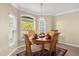 Dining room with an area rug, wood table set, and view of the large window at 733 Palma Dr, The Villages, FL 32159