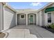 Covered front entrance featuring white columns, concrete, and a turquoise front door at 733 Palma Dr, The Villages, FL 32159
