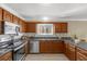 Kitchen features stainless steel appliances, granite counters, and warm wood cabinets at 733 Palma Dr, The Villages, FL 32159