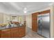 Open kitchen featuring stainless fridge, granite counters and wooden cabinets at 733 Palma Dr, The Villages, FL 32159
