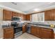 Well-lit kitchen with stainless steel appliances, granite countertops, and wood cabinets at 733 Palma Dr, The Villages, FL 32159