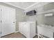Bright laundry room features a utility sink, white washer and dryer, and a wire rack shelf for storage at 733 Palma Dr, The Villages, FL 32159