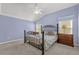 Comfortable main bedroom with blue walls, a ceiling fan, large windows, and carpet floors at 733 Palma Dr, The Villages, FL 32159