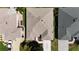 An aerial view features the roof of a home with neutral tones, driveway, and landscaping at 737 Caldwell Ct, The Villages, FL 32162