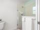 Modern bathroom features a sleek glass shower and crisp white tiling, combining elegance with functionality at 737 Caldwell Ct, The Villages, FL 32162