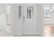 Elegant front door features decorative glass and sidelight, set in a neutral interior with outside light through adjacent window at 737 Caldwell Ct, The Villages, FL 32162