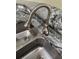 Close up of a stainless steel kitchen sink with a modern faucet and granite countertops at 737 Caldwell Ct, The Villages, FL 32162