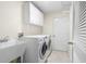 Well-equipped laundry room with modern washer and dryer, sink, and ample storage cabinets for efficient laundry care at 737 Caldwell Ct, The Villages, FL 32162