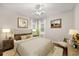 This staged bedroom includes a decorative ceiling fan, neutral paint, and wood flooring at 7636 Lake Angelina Dr, Mount Dora, FL 32757