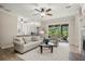 Bright living room with comfortable seating, a ceiling fan, and access to the outdoor patio area at 7636 Lake Angelina Dr, Mount Dora, FL 32757