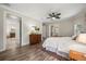 Spacious main bedroom with a ceiling fan, wood floors, and an ensuite bathroom with a soaking tub at 7636 Lake Angelina Dr, Mount Dora, FL 32757