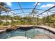 Beautiful screened-in pool area with a waterfall feature and brick paver decking at 7636 Lake Angelina Dr, Mount Dora, FL 32757