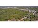 Aerial view of a wooded lot, outlined in red, surrounded by lush greenery and close to the city at 801 Kilgore St, Wildwood, FL 34785