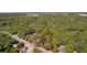 Aerial view of a lot marked in red, surrounded by mature trees and close to a paved road, offering convenient access at 801 Kilgore St, Wildwood, FL 34785
