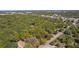 A vacant lot is surrounded by mature trees, offering privacy and bordered by a road at 801 Kilgore St, Wildwood, FL 34785