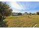Expansive backyard with a chainlink fence, mature trees, green lawn, and home exterior at 9857 Sw 63Rd Ct, Ocala, FL 34476