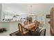 Inviting dining room featuring a wooden table with seating for six, flowing into an open-concept kitchen and sunroom at 9857 Sw 63Rd Ct, Ocala, FL 34476