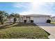 Charming single-story home with a well-maintained lawn, palm trees, and an attached two-car garage at 9857 Sw 63Rd Ct, Ocala, FL 34476