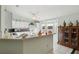 Well-lit kitchen featuring white cabinetry, a breakfast bar, and modern appliances with white tile flooring at 9857 Sw 63Rd Ct, Ocala, FL 34476