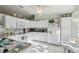 Bright kitchen with white cabinetry, white appliances, white countertops and tiled flooring at 9857 Sw 63Rd Ct, Ocala, FL 34476