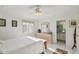 Bright main bedroom with a ceiling fan, dresser, and an ensuite bathroom, offering comfort and convenience at 9857 Sw 63Rd Ct, Ocala, FL 34476