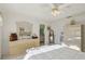Tranquil bedroom with ensuite bathroom access, a dresser and a ceiling fan, with tile flooring at 9857 Sw 63Rd Ct, Ocala, FL 34476