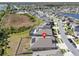 Aerial view of a neighborhood showcasing well-maintained homes with solar panels and a community lake at 197 Pineywoods St, St Cloud, FL 34772