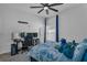 Bright bedroom features a large ceiling fan, plush bed, work station, and ample natural light from the window at 197 Pineywoods St, St Cloud, FL 34772