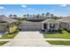 Beautifully landscaped single-story home featuring a three-car garage and inviting front porch at 197 Pineywoods St, St Cloud, FL 34772