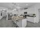 Modern kitchen boasts white cabinets, stainless appliances, island seating, and stylish pendant lighting at 197 Pineywoods St, St Cloud, FL 34772