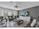 Comfortable living room with a mounted television, modern gray accents, and abundant natural light at 197 Pineywoods St, St Cloud, FL 34772