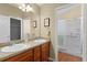 Bathroom featuring double sinks, a walk-in shower, and a separate closet at 2186 Quinn Ln, The Villages, FL 32162