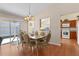 Inviting dining area with laminate floors, stylish chandelier, and sliding door access to the outside at 2186 Quinn Ln, The Villages, FL 32162