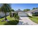 Charming single-story home with a well-manicured lawn, a palm tree, and a two-car garage at 2186 Quinn Ln, The Villages, FL 32162