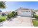 Home exterior with two-car garage, driveway and mature landscaping at 2186 Quinn Ln, The Villages, FL 32162